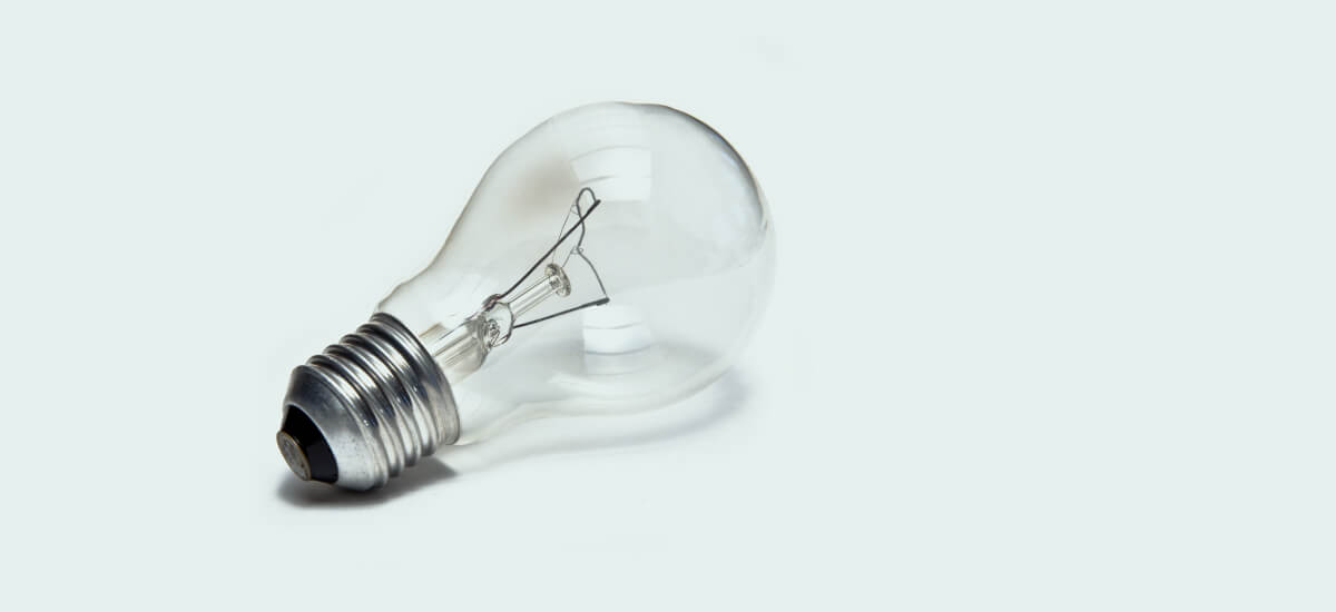 an incandescent light bulb on a light green background